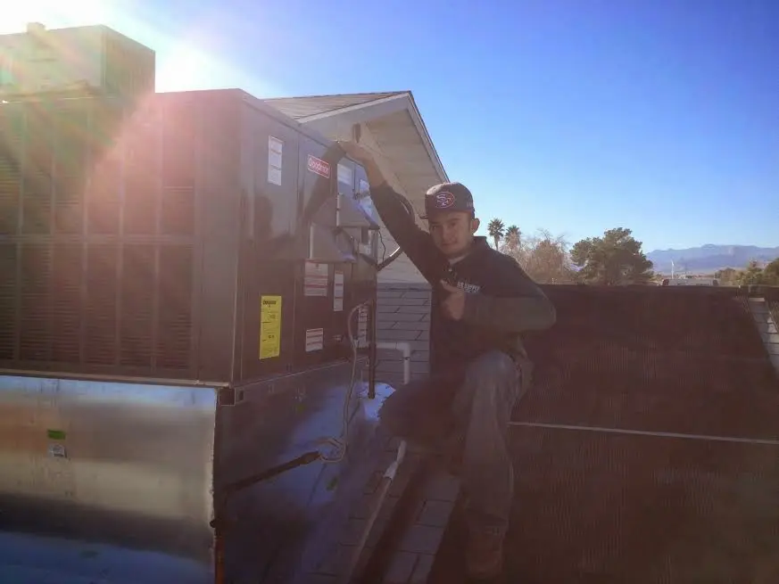 HVAC technician performing AC Tune-Up on a rooftop unit in Bayshore Gardens